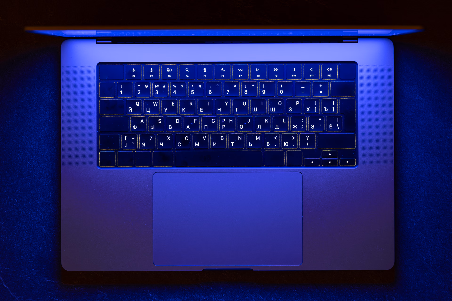 Laptop keyboard lit by blue neon light at night, a visual for how to choose a local SEO agency.