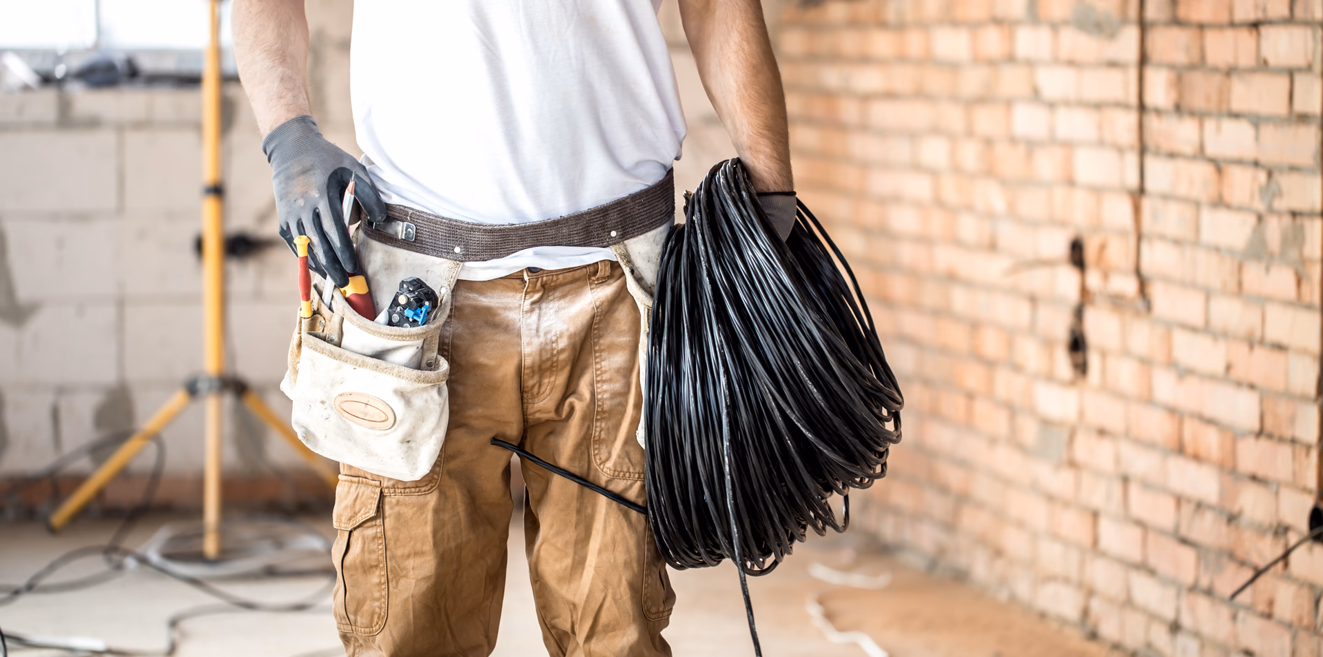 Website Handwerker: Dachdecker prüft die Seite seines Betriebs auf dem Smartphone vor einer Baustelle.